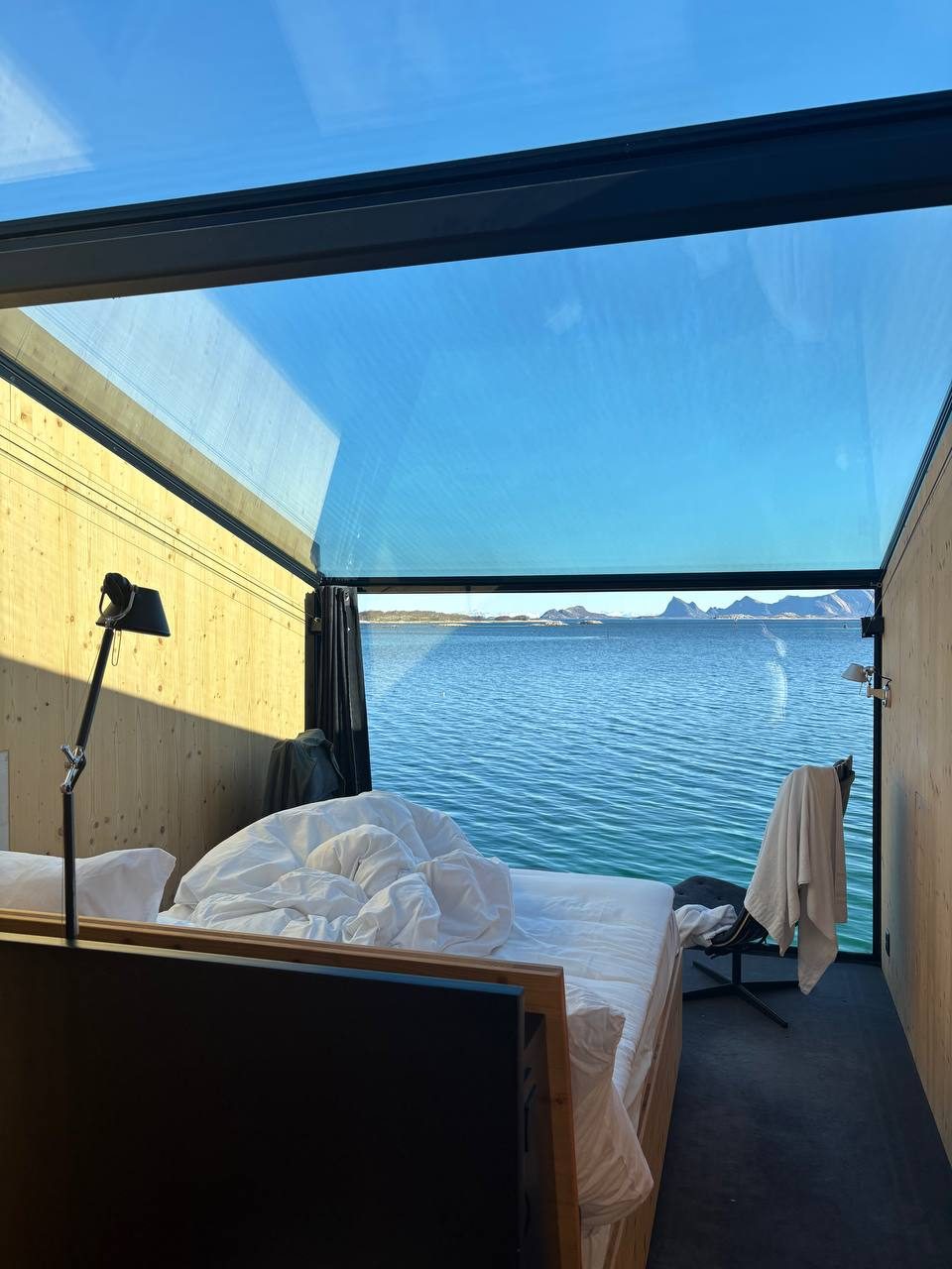 Ranní výhled z postele stropem a čelní stěnou na moře