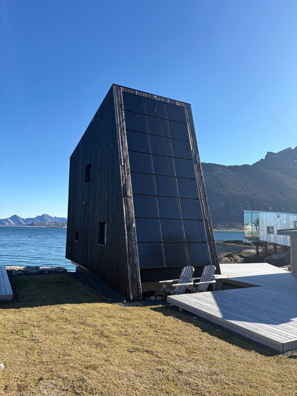 Ohořelá bouda s solárními panely a trávníkem