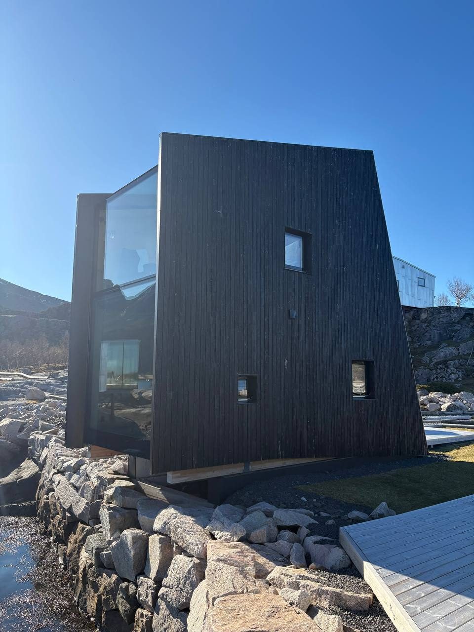 Ohořelá bouda na skále se skleněnou stěnou