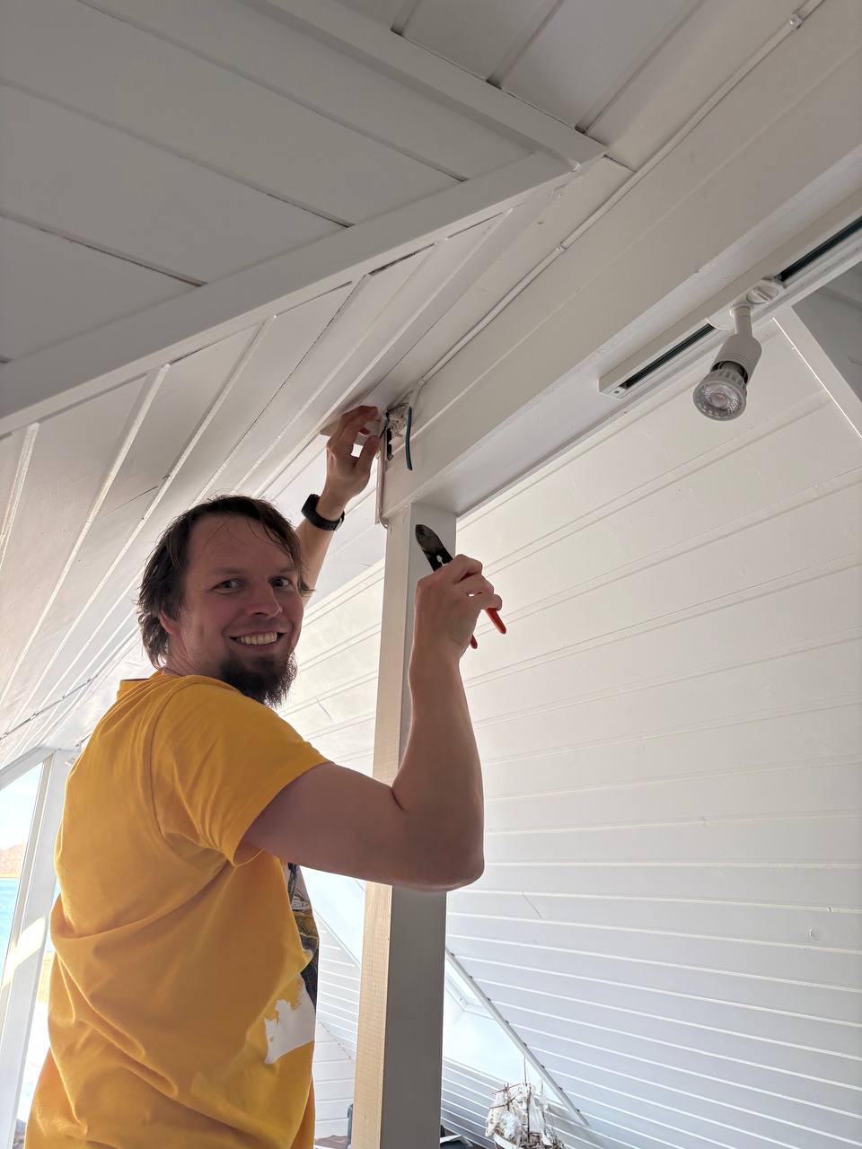 Vaklaf v žlutém triku zapojuje kabel ve stropní krabici