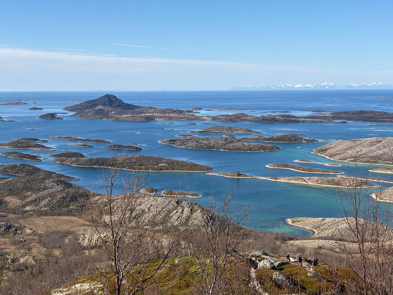 Strmý skalnatý terén s výhledem na souostroví, tyrkysové kanály mezi ostrovy