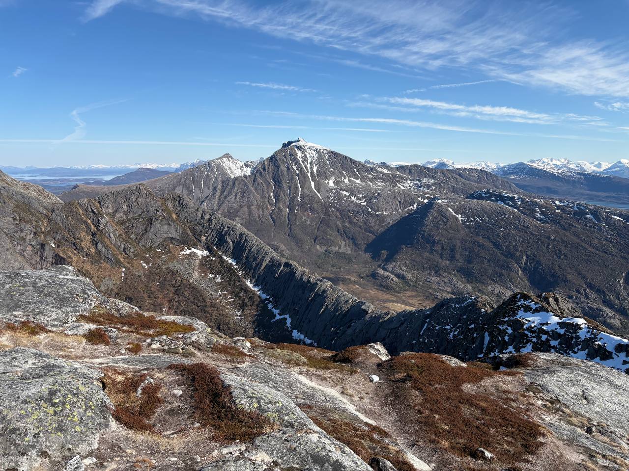 Horský hřeben v dálce, vrstvy kopců se sněhem a řídkou vegetací
