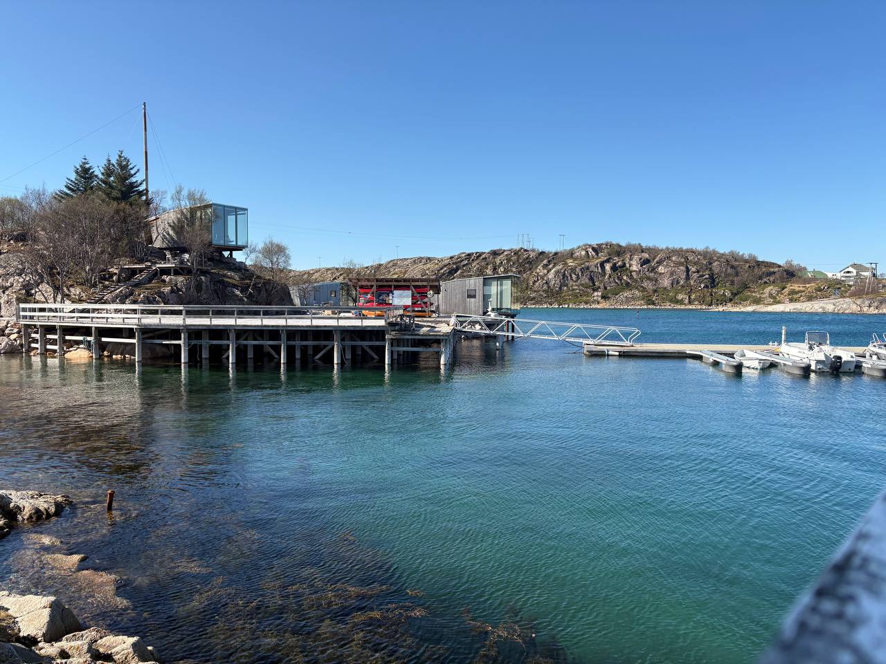 Stejný přístav při přílivu, tyrkysová voda sahá vysoko, lodě plovoucí u mola